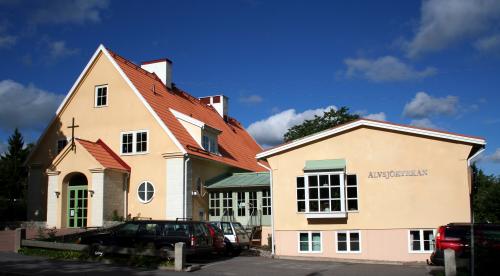Foto av Älvsjökyrkan: tre våningar, gul fasad.